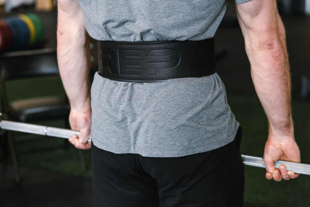 Athlete performing a deadlift while wearing a black REP Premium Leather Lifting Belt.