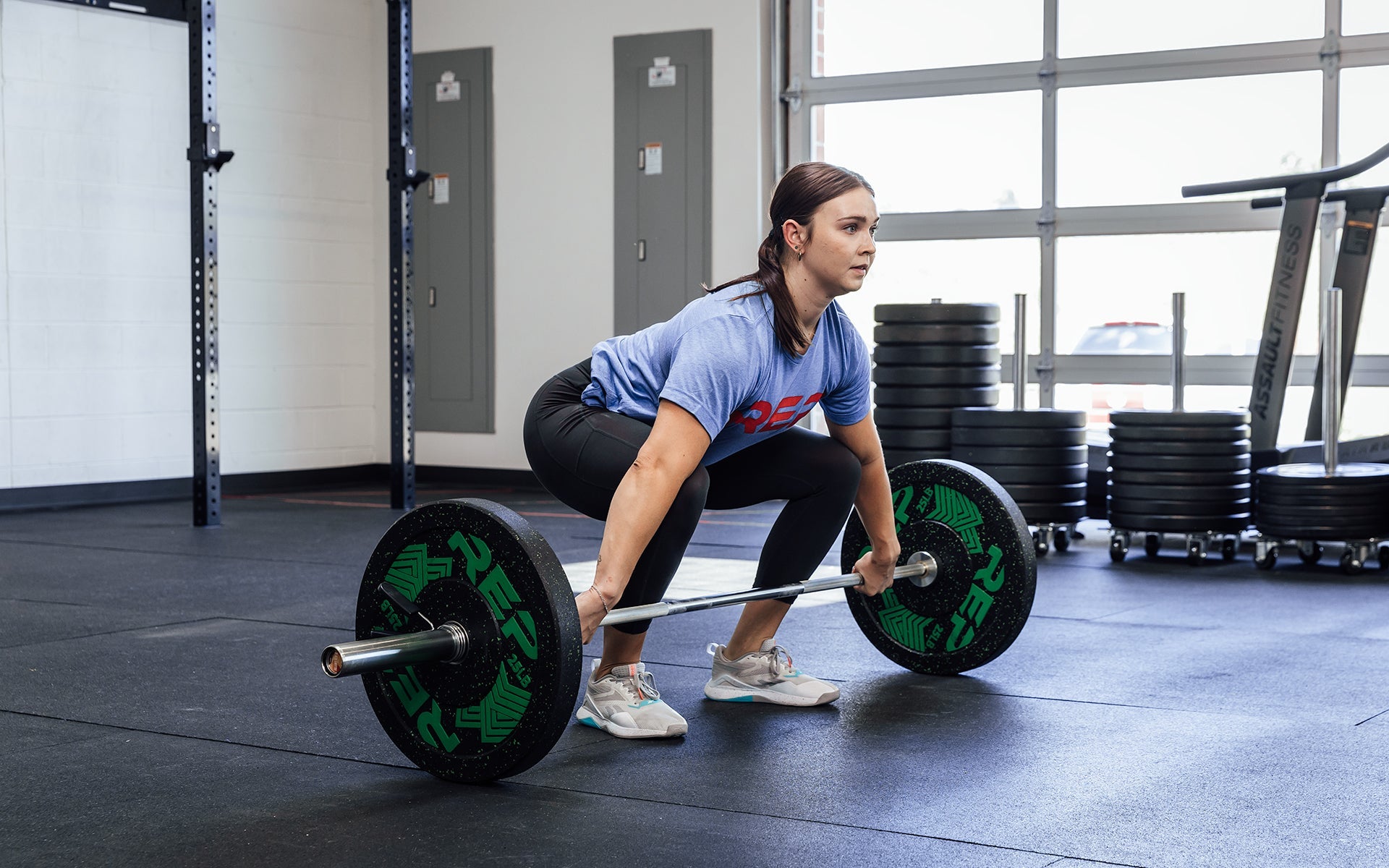 Female lifter preparing to perform a snatch with a loaded REP 15kg Black Canyon Bar.