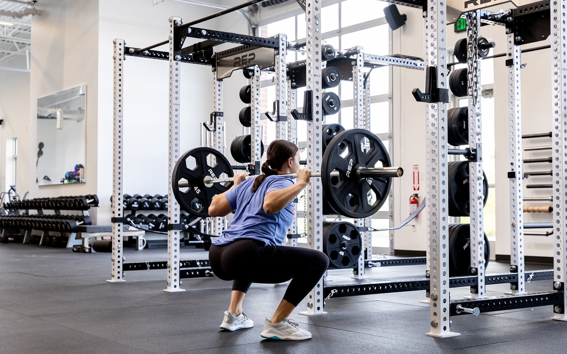 Lifter back squatting with the REP 15kg Black Canyon Bar.