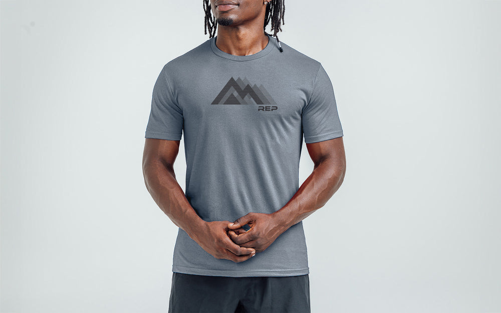 An athlete wearing the REP Fitness Summit Tri-Blend Crew T-Shirt in Heather Flint and Black