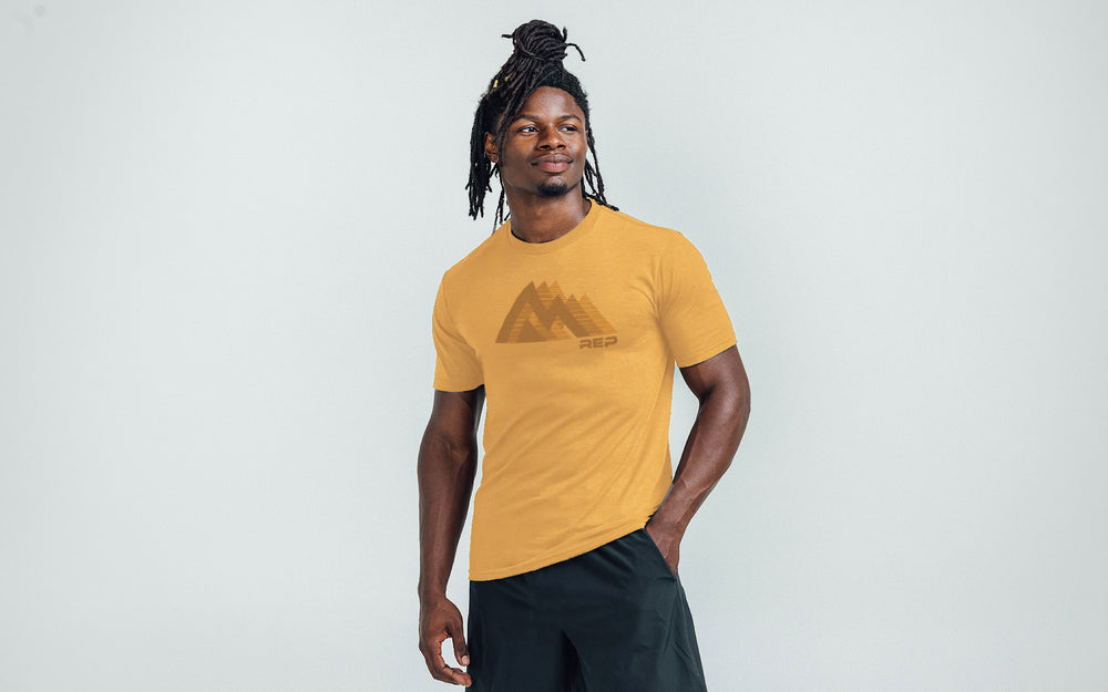 An athlete wearing the REP Fitness Summit Tri-Blend Crew T-Shirt in Heather Ochre and Brown
