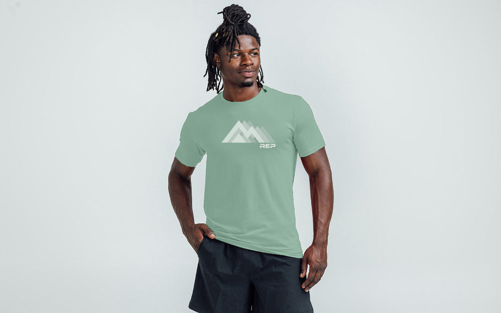 An athlete wearing the REP Fitness Summit Tri-Blend Crew T-Shirt in Heather Sage and White