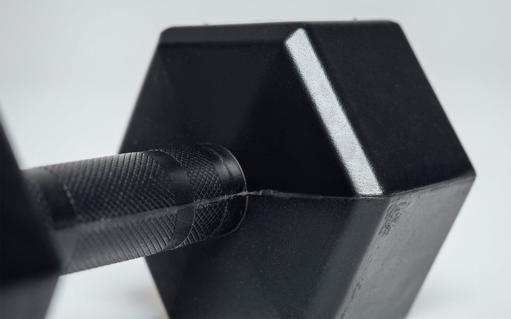 Close-up view of the center-knurled ergonomic handle of a Rubber Coated Hex Dumbbell.