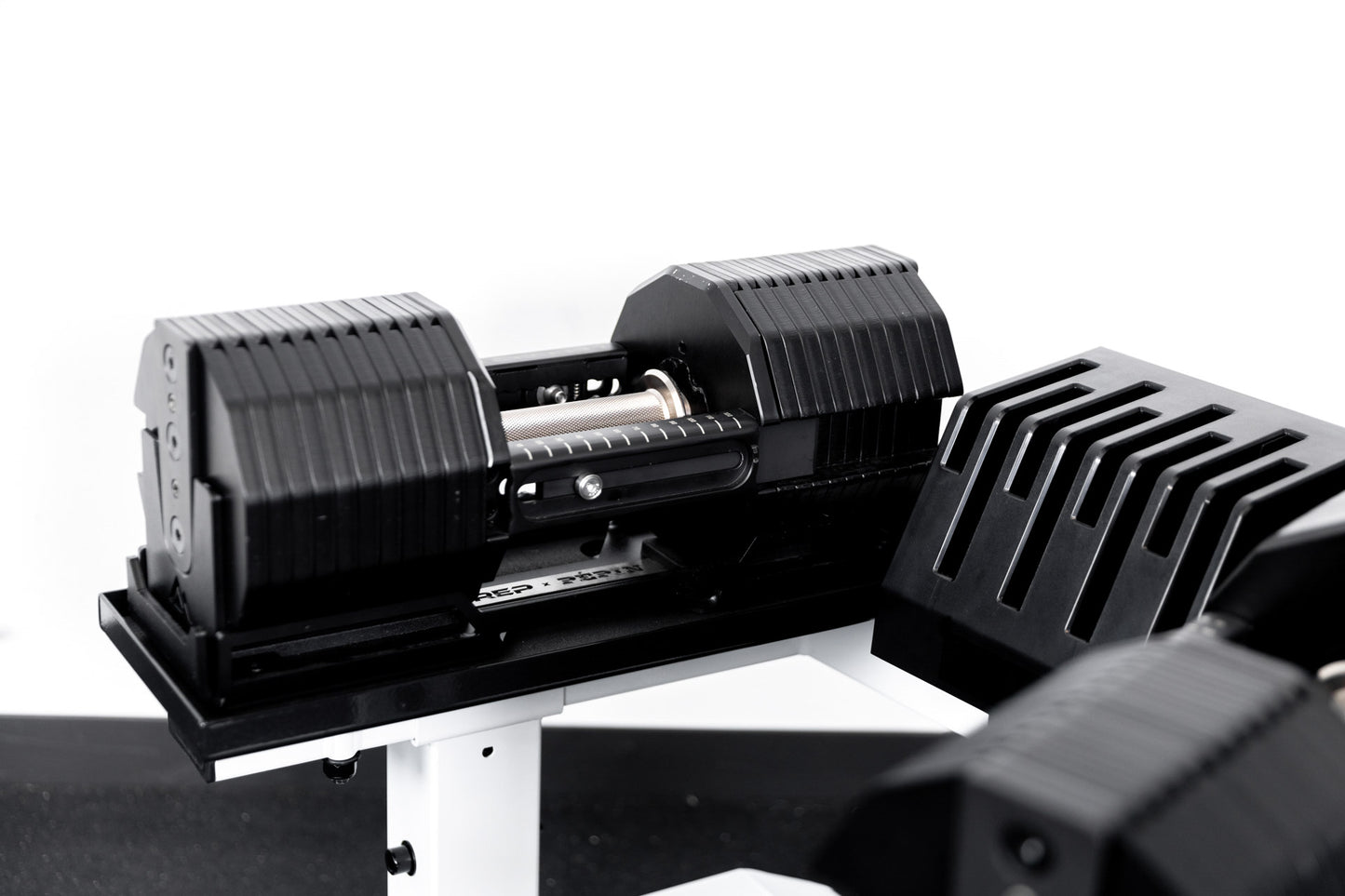 REP® x PÉPIN™ adjustable dumbbells on  a white REP® Adjustable Dumbbell Stand