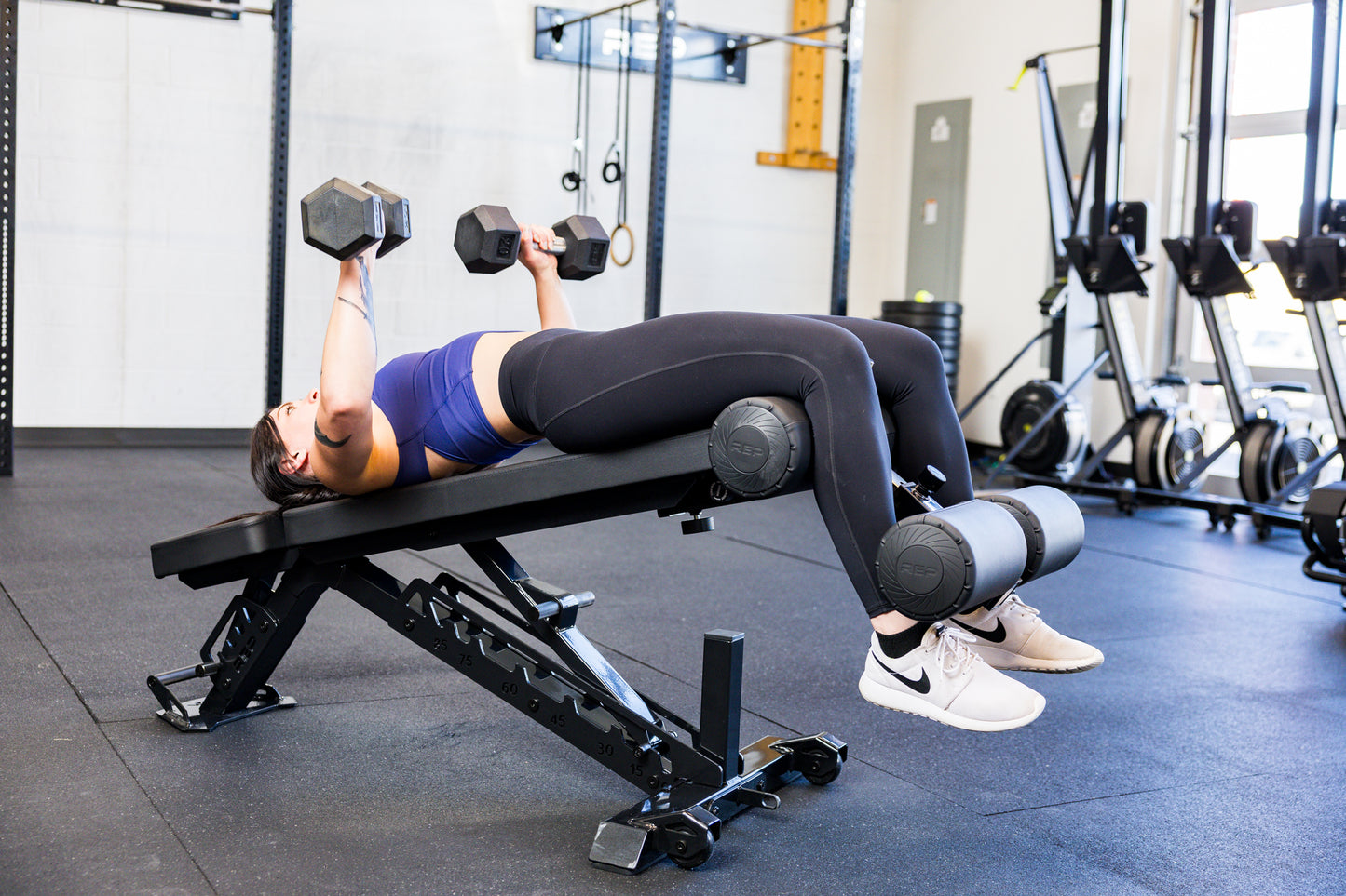 Athlete decline dumbbell bench pressing with the Adjustable Bench Leg Roller Attachment 2.0