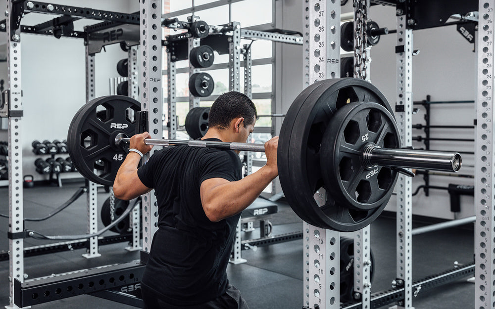 Male lifter getting ready to unrack a loaded REP Delta Basic Bar to perform  a back squat.