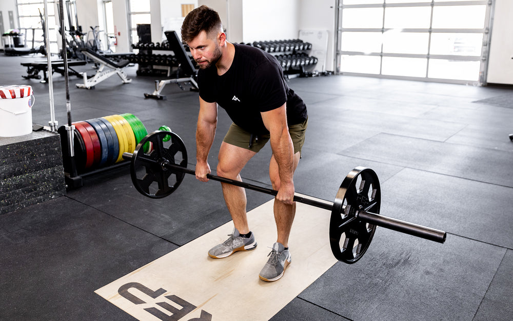 Lifter performing a deadlift with a barbell loaded with a pair of 45lb USA-Made Equalizer Iron Plates.