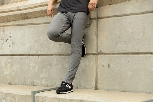 Men's Pants & Joggers - Athlete in grey Men's Felix Pants 2.0 leaning on a ledge