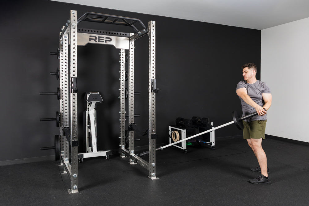 Athlete using a landmine attachment on a rack built with stainless steel crossmembers