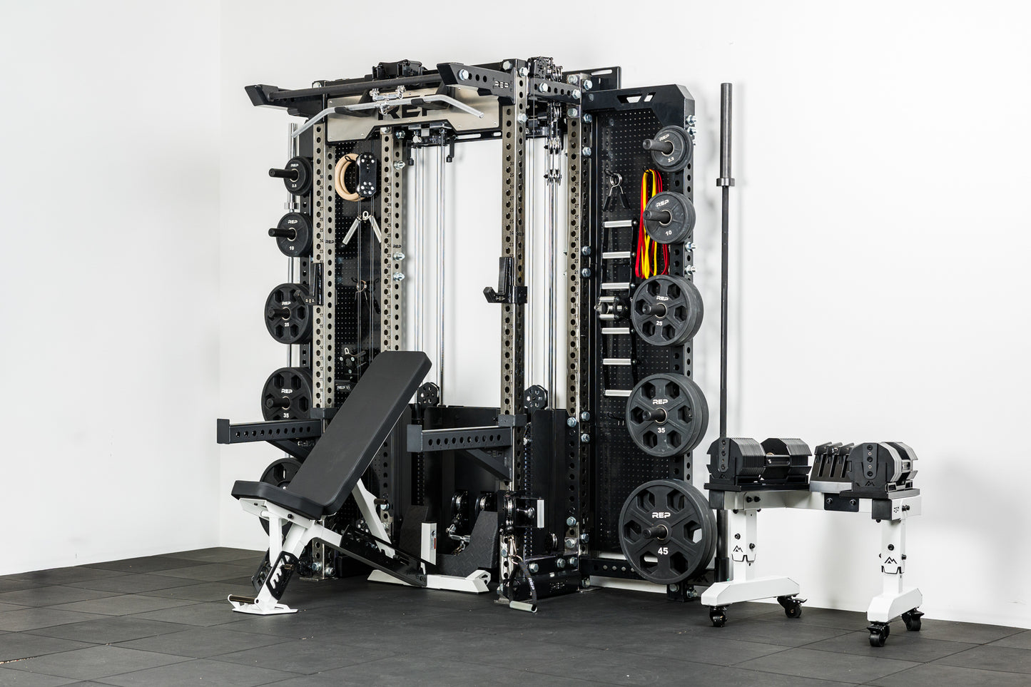 The REP Fitness Compact Home Gym Setup with the Wall-Mounted Ares 2.0, Nighthawk adjustable bench, and Equalizer™ Urethane-Coated Plates
