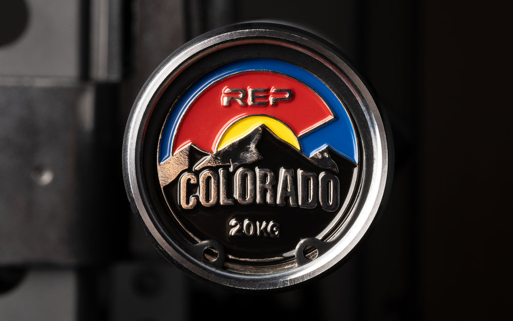 Close-up view of the uniquely designed metal endcap of a racked REP 20kg Colorado Bar.