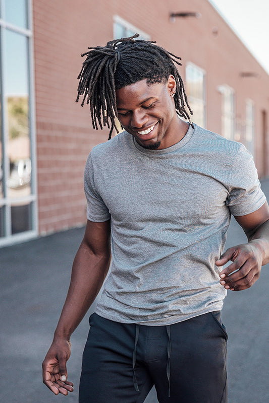 Clearance Apparel - Man wearing a gray t-shirt and black pants outdoors