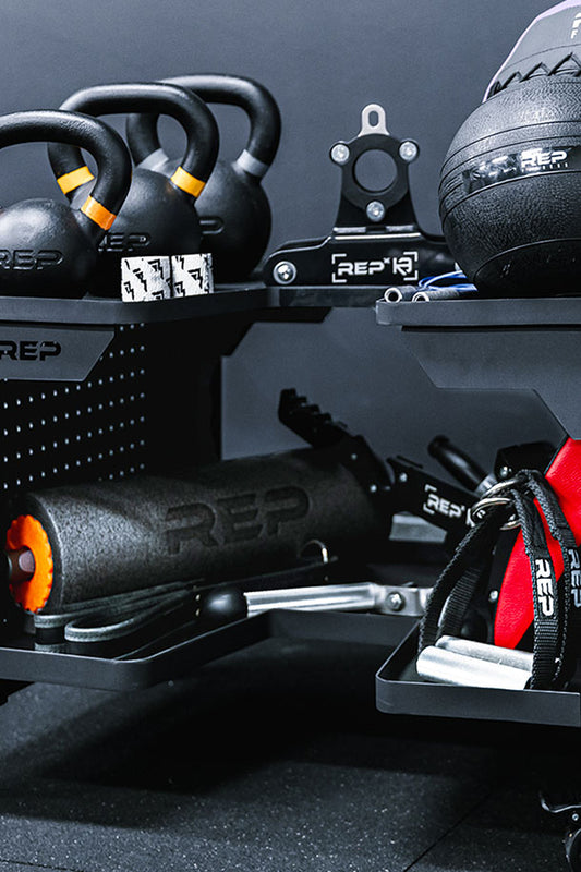 Deals - Gym equipment including kettlebells and resistance bands on a dumbbell cart with 'REP' branding on a dark background.