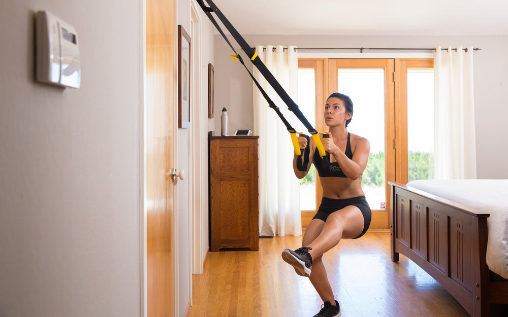 Action shot: Athlete working out with the TRX® STRONG System inside their bedroom