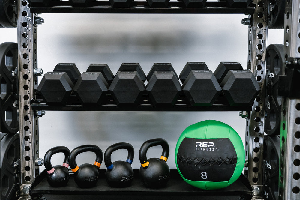 Close up of the dumbbell shelf and flat storage shelf. In-Rack Storage holding dumbbells, kettlebells, and medicine ball