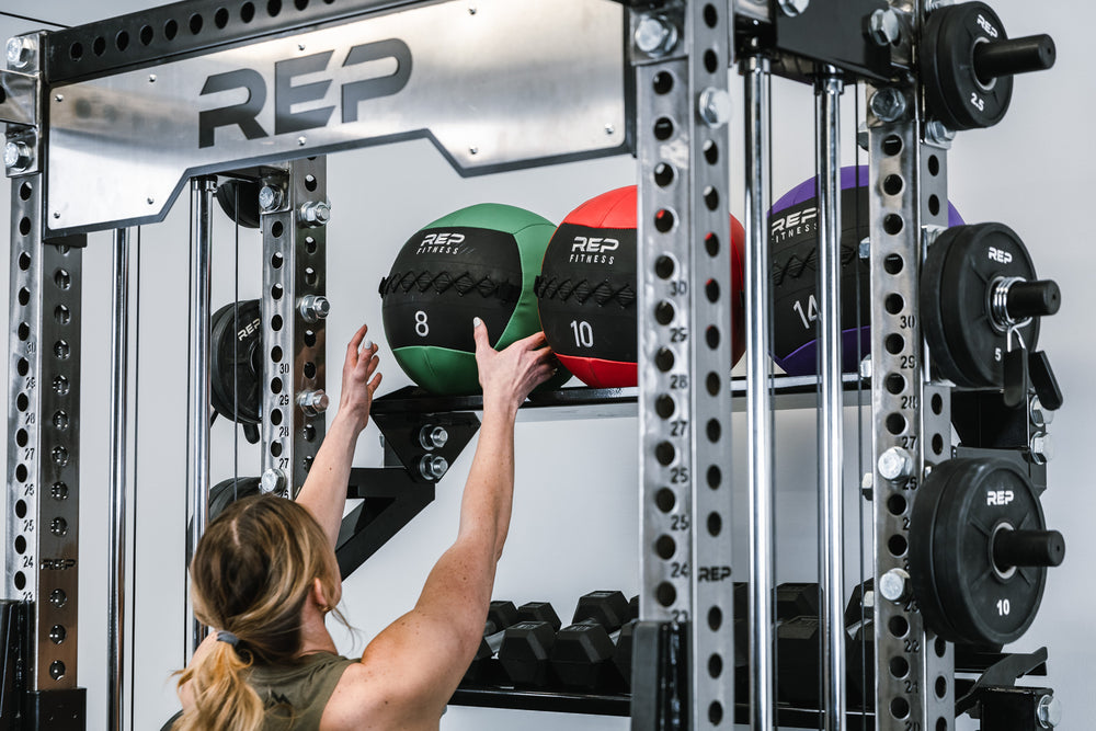 In-Rack Storage Showing Someone grabbing a medicine ball off of the Flat Storage Shelf