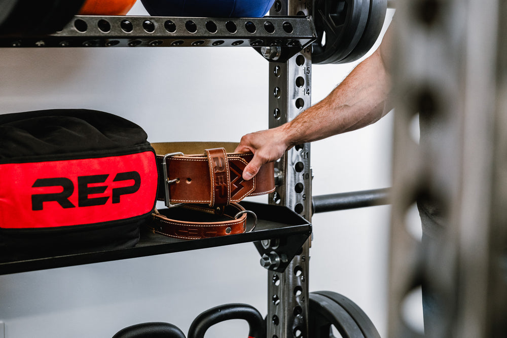 Kettlebell Storage Shelf - Versatility - Showing weightlifting belt and stone sandbag being stored