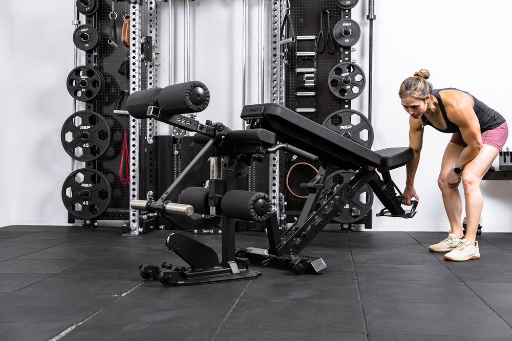 Athlete wheeling a Nighthawk bench up to the Leg Extension & Leg Curl Bench Attachment