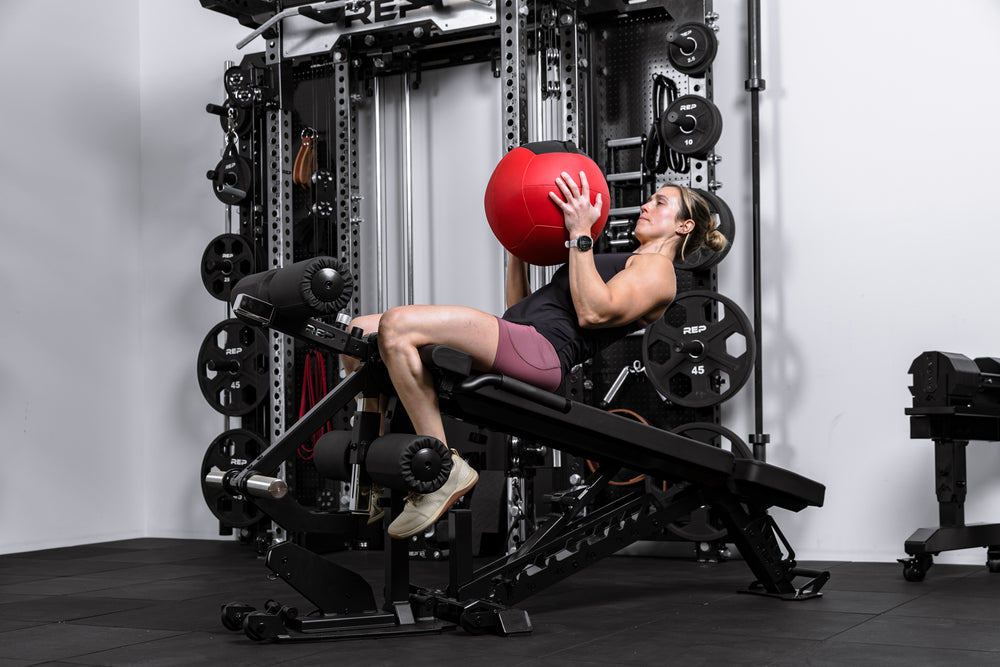 Athlete doing sit ups on the Leg Extension & Leg Curl Bench Attachment on a Nighthawk