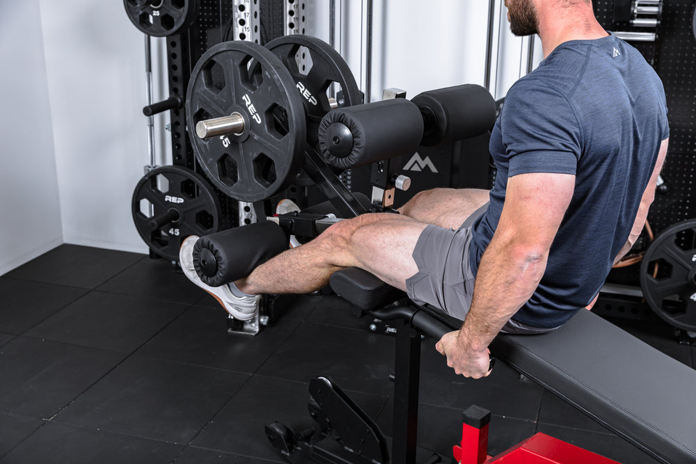 Athlete holding the handles on the Leg Extension & Leg Curl Bench Attachment
