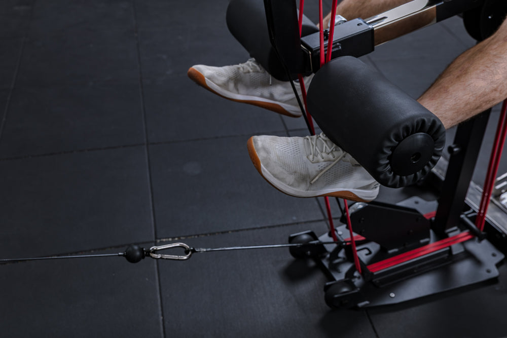 Close-up of a resistance band and cable kit being used on the Leg Extension & Leg Curl Bench Attachment