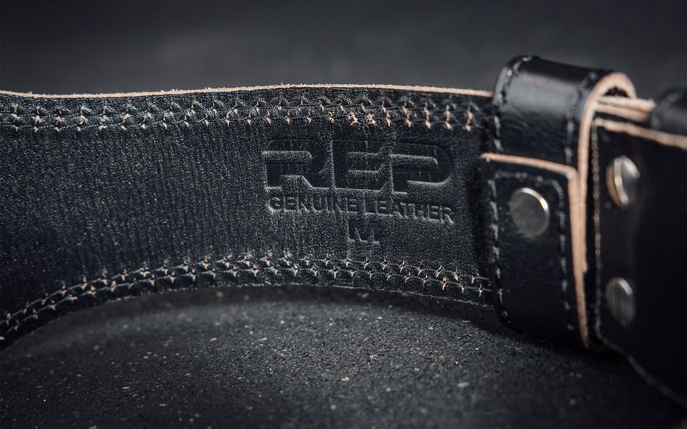 Close-up view of the debossed "REP" and "GENUINE LEATHER" on the inside of the black REP Leather Olympic Lifting Belt.