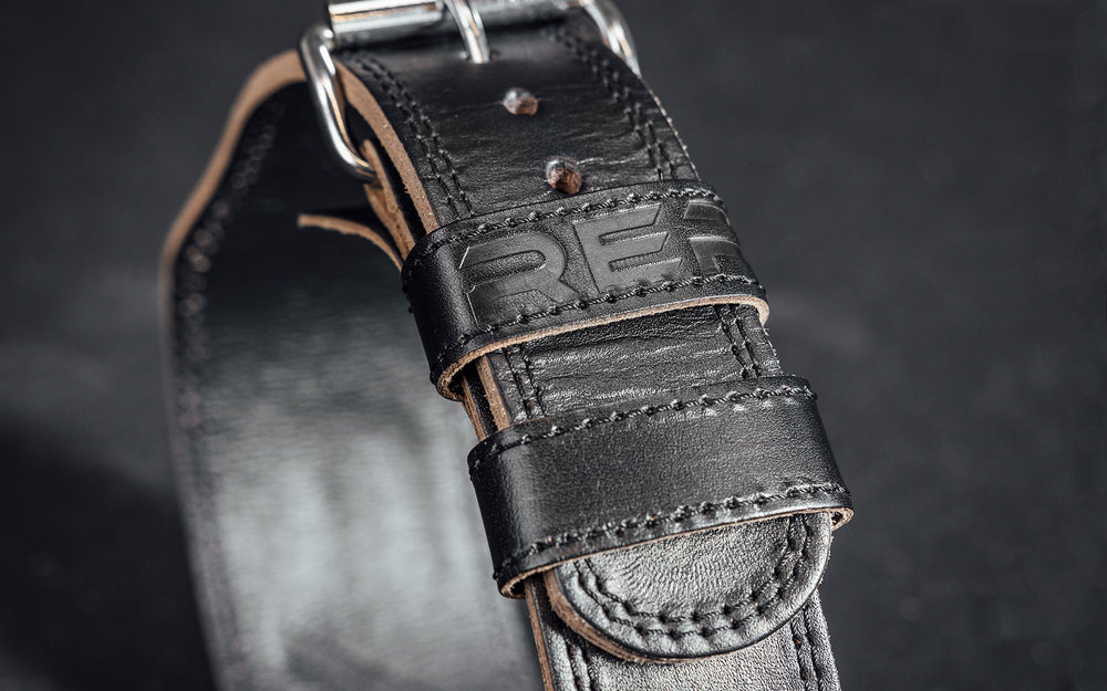 Close-up view of the belt loop and buckle portion of the black REP Leather Olympic Lifting Belt.