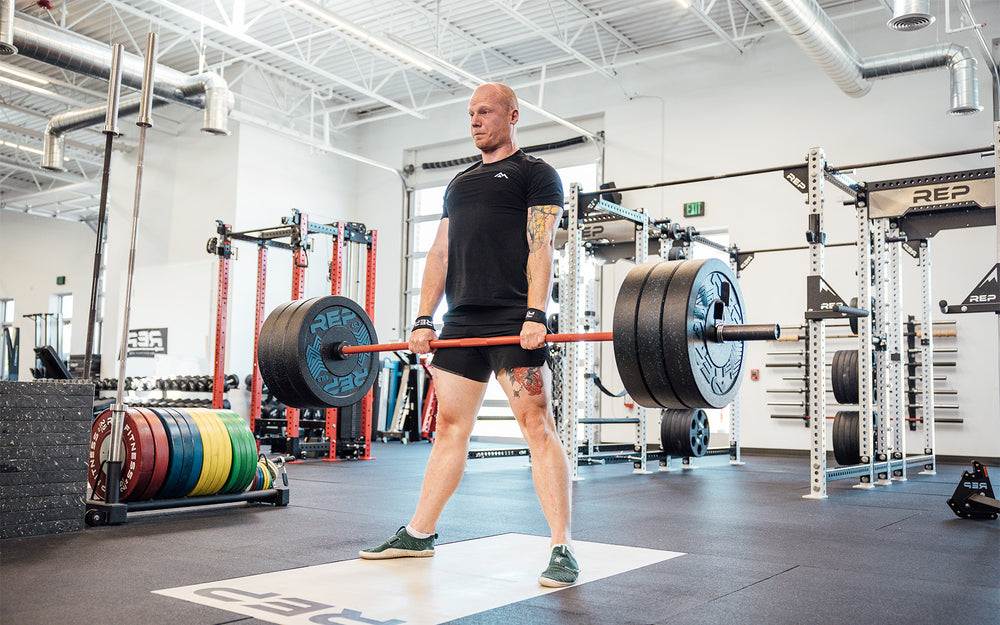 Lifter performing a deadlift while wearing REP Lifting Straps..