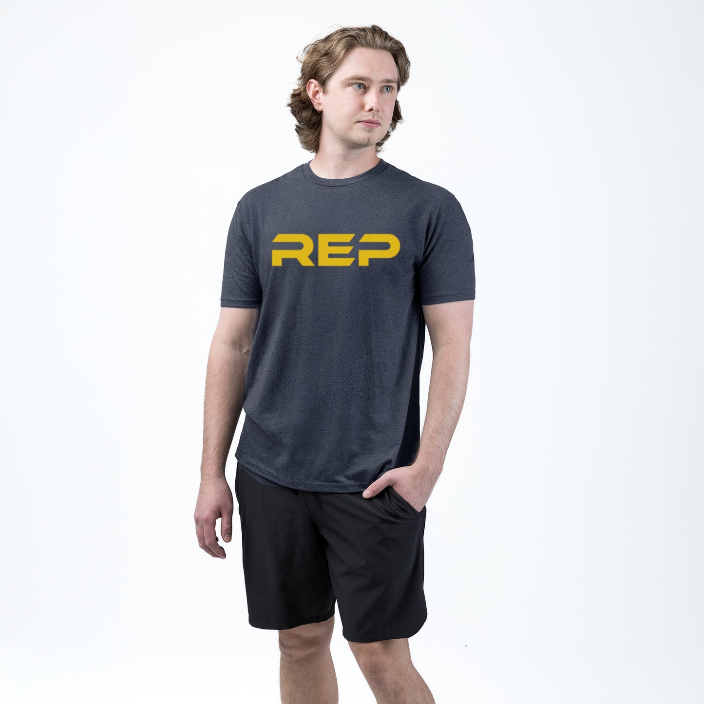 An athlete wearing the REP Fitness Men's Daily Driver 2.0 Tri-Blend Crew T-Shirt in Heather Navy/Yellow