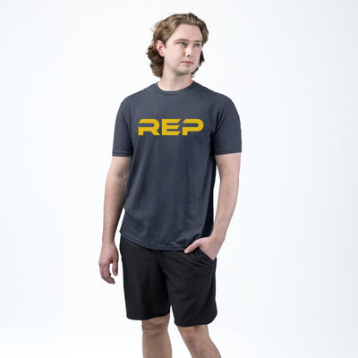 An athlete wearing the REP Fitness Men's Daily Driver 2.0 Tri-Blend Crew T-Shirt in Heather Navy/Yellow