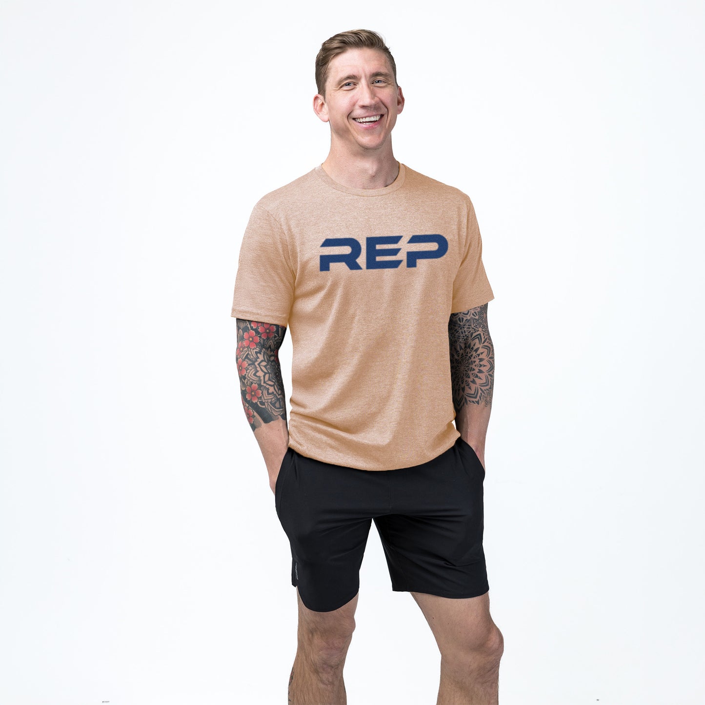 An athlete wearing the REP Fitness Men's Daily Driver 2.0 Tri-Blend Crew T-Shirt in Heather Peach/Blue