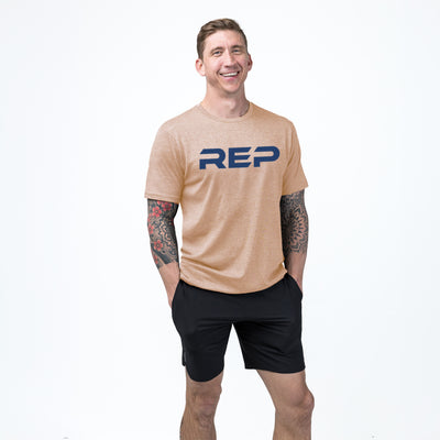 An athlete wearing the REP Fitness Men's Daily Driver 2.0 Tri-Blend Crew T-Shirt in Heather Peach/Blue