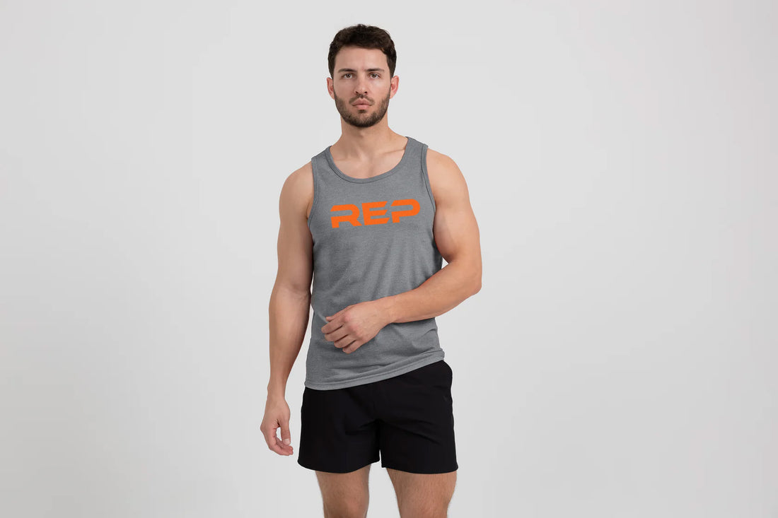 The REP Fitness Men's Daily Driver Tri-Blend Tank in Heather Aluminum/Orange  on body