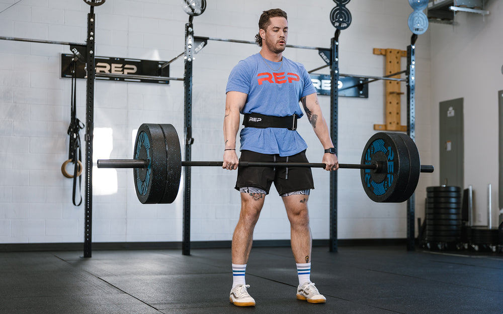 Athlete performing a deadlift while wearing the REP Nylon Lifting Belt.