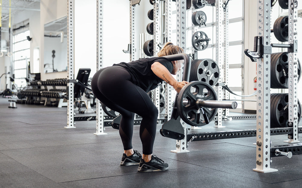 Female athlete performing a good morning with the REP Open Trap Bar.