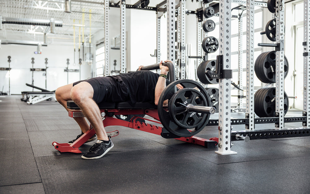 Male athlete performing a bench press with the REP Open Trap Bar.