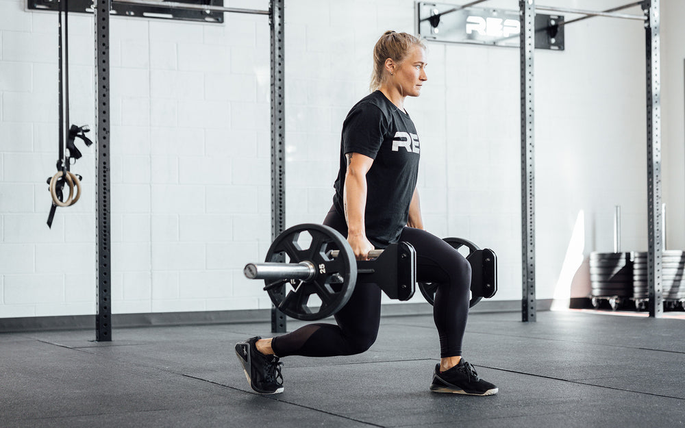 Female athlete performing a lunge with the REP Open Trap Bar.