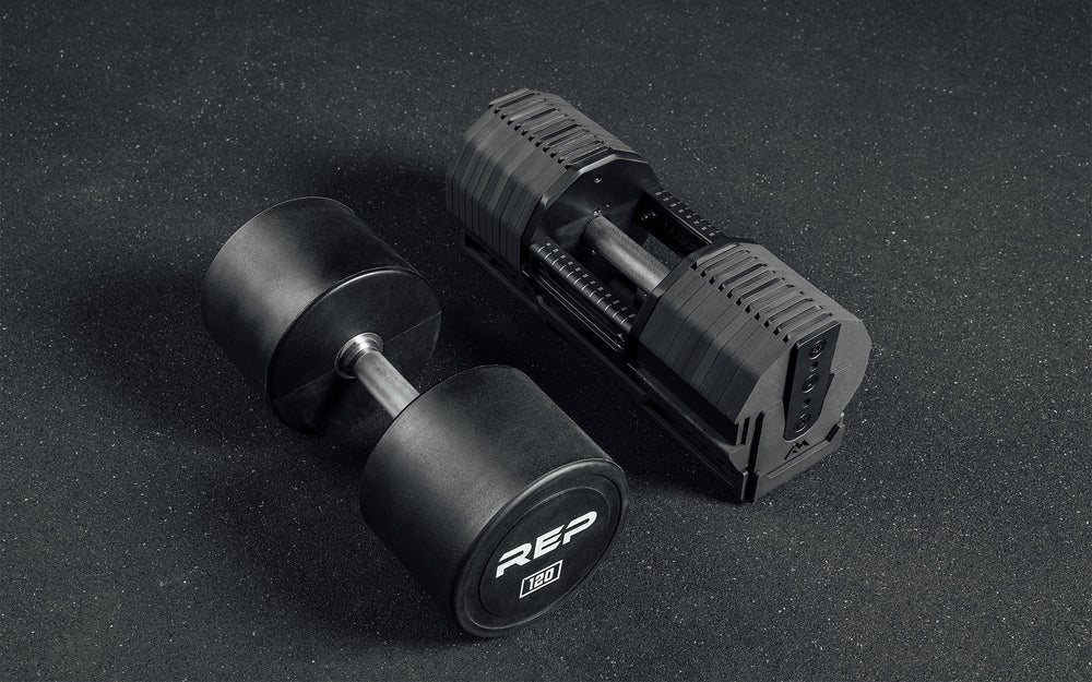 A single 125lb REP x PÉPIN FAST Series Adjustable Dumbbells next to a 120lb REP Urethane-Coated fixed dumbbell.