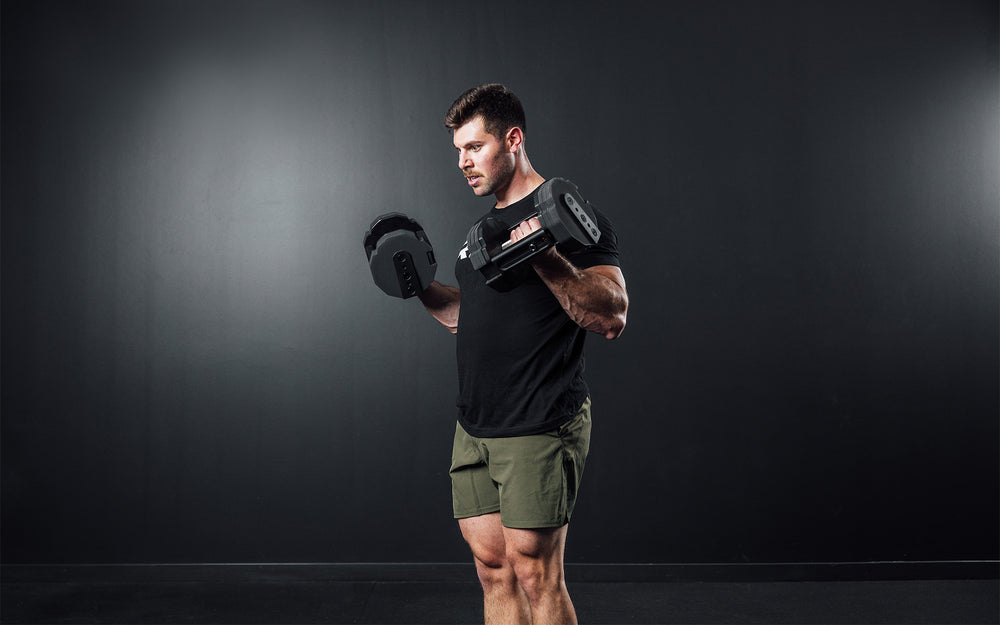 Athlete performing curls with a pair of REP x PÉPIN FAST Series Adjustable Dumbbells.