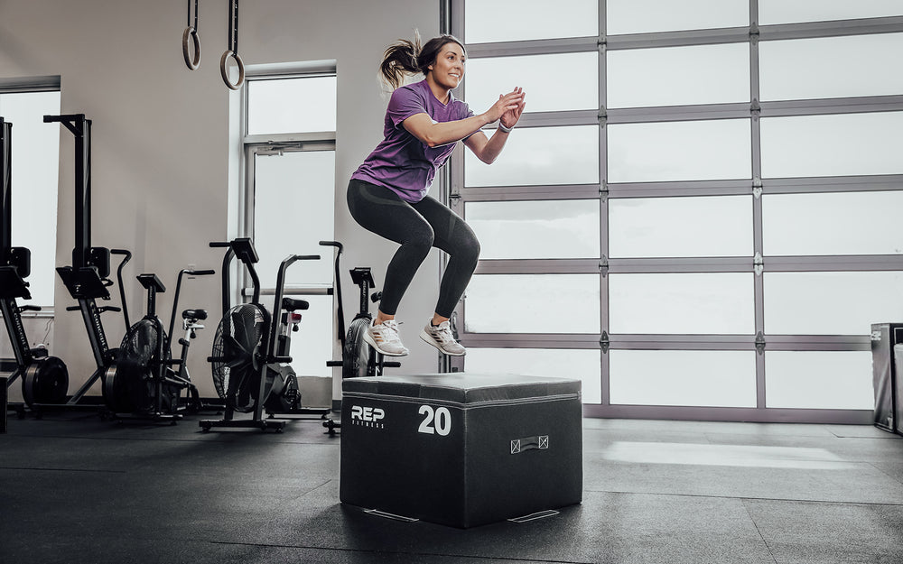 Female athlete performing box jumps on a 20" REP Stackable Soft Plyo Box.