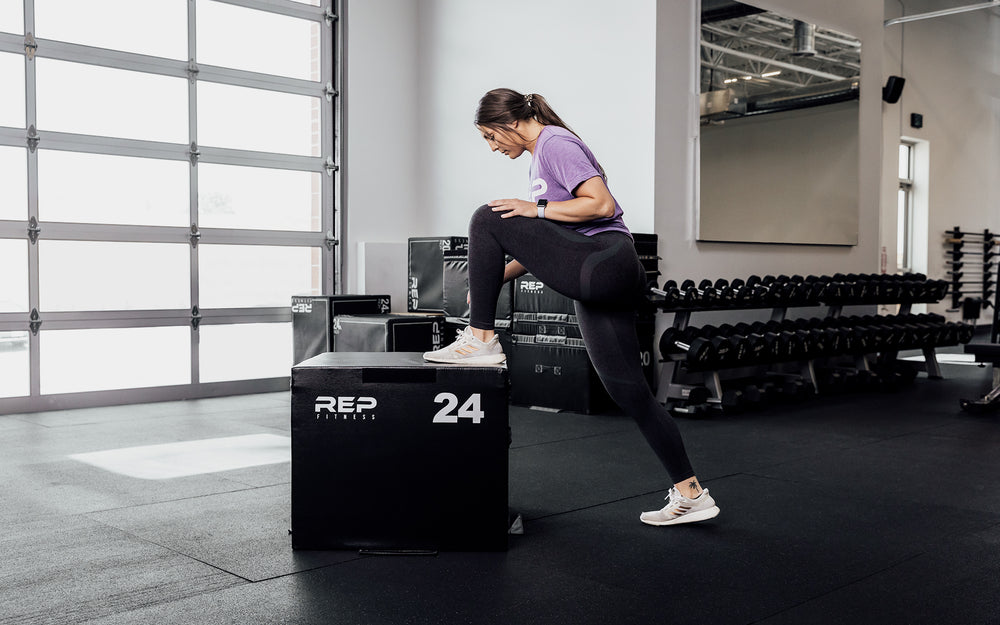 Female athlete stretching against a 24" REP Stackable Soft Plyo Box.