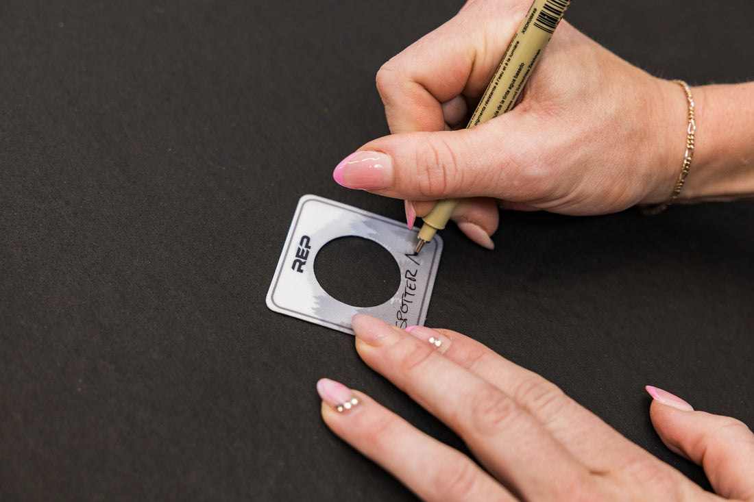 Athlete writing "Spotter Arms" on the blank Power Rack Magnetic Position Marker