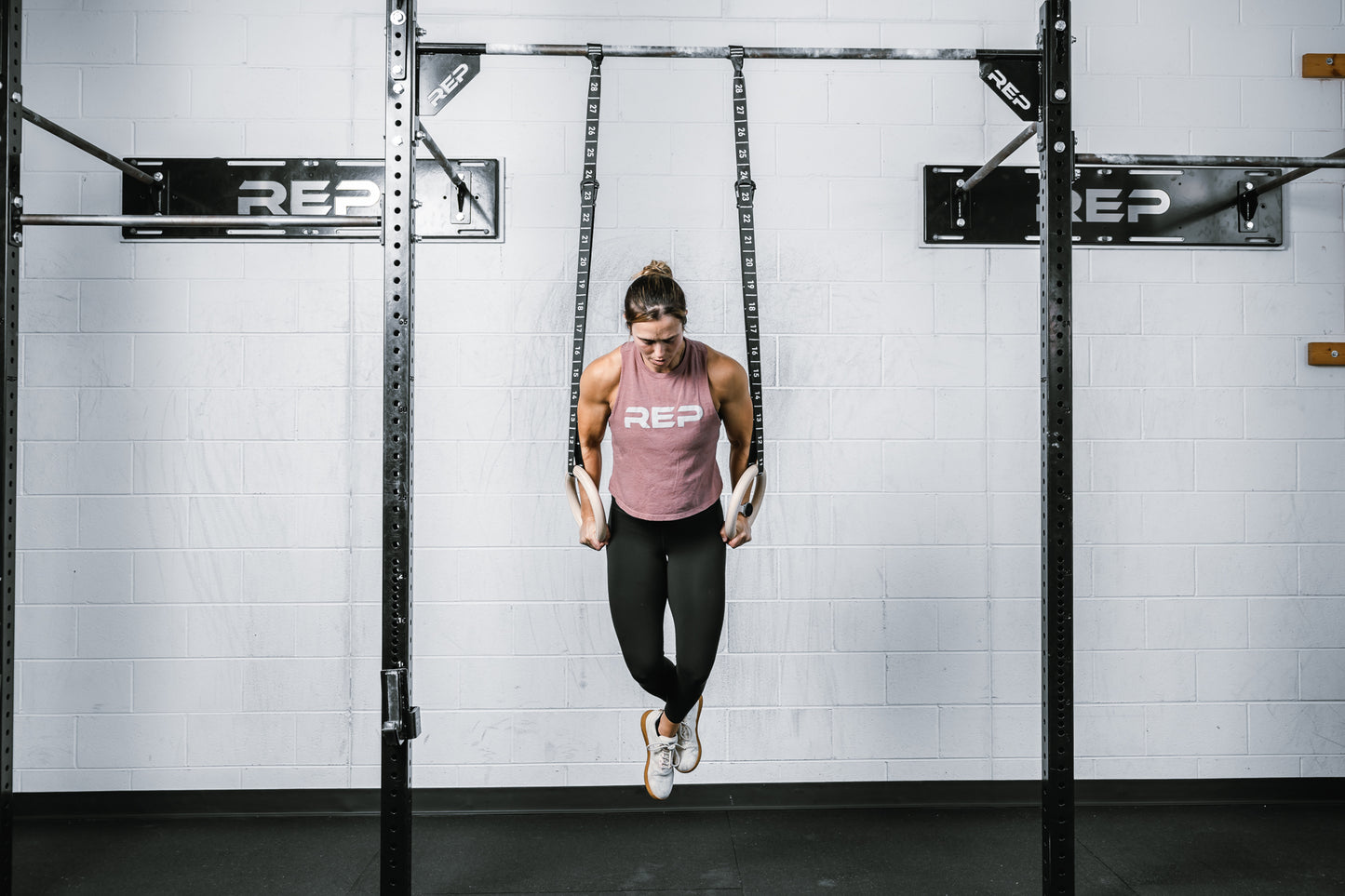 Athlete holding themselves vertically on the REP Competition Gymnastic Straps to the Wood Rings on a REP Wall-mounted Rig