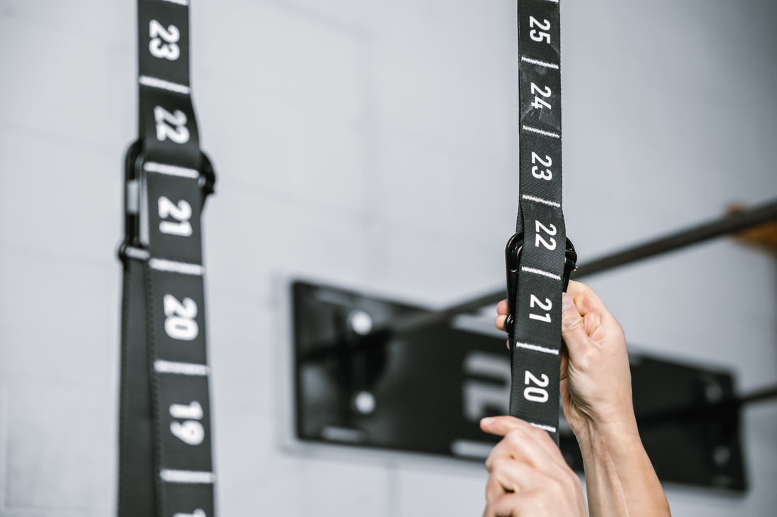 Close-up shot of an athlete securing the carabiner at section 22 of both REP Competition Gymnastic Straps