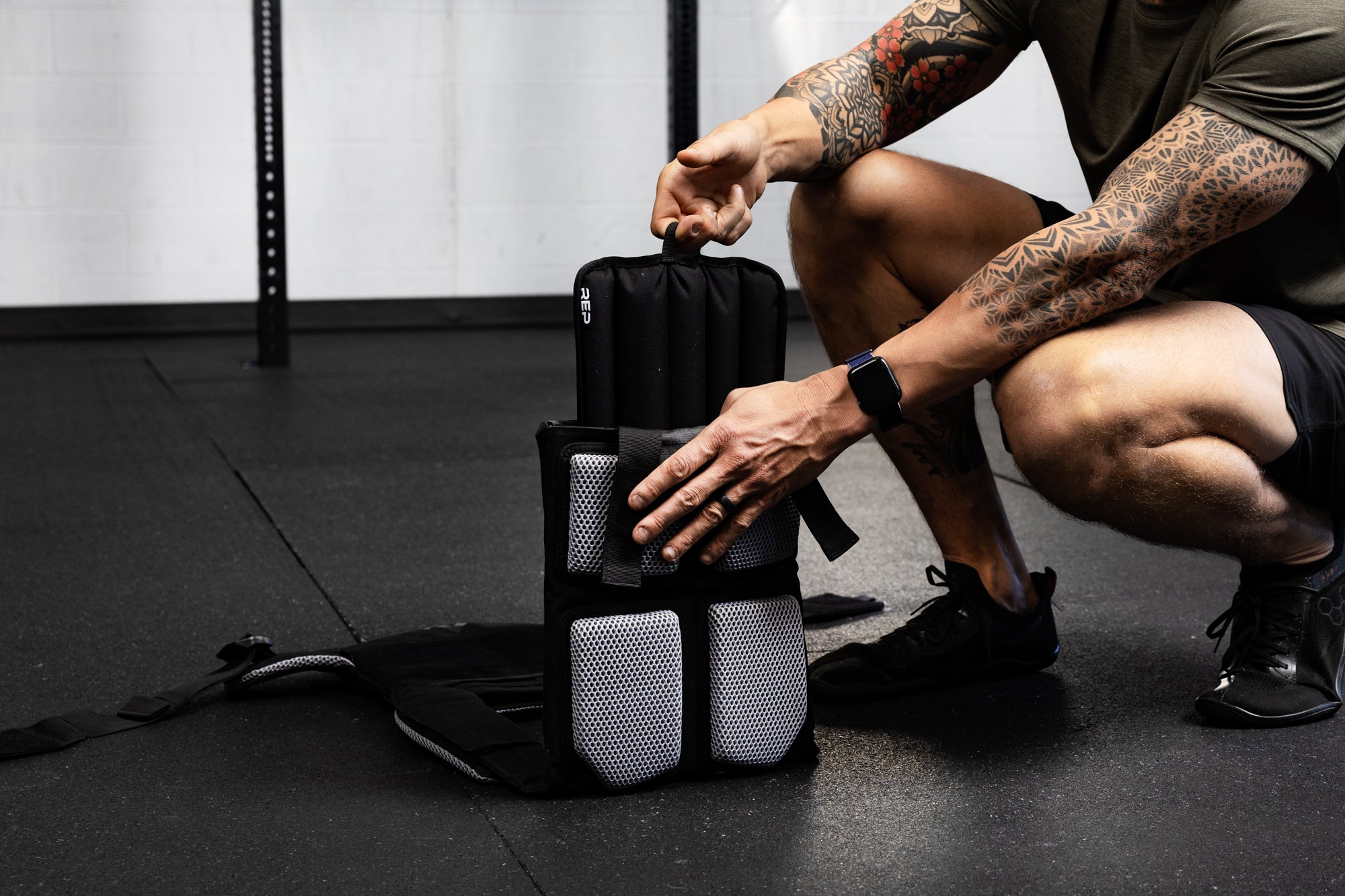 Person inserting soft weight vest plate into the weight vest.