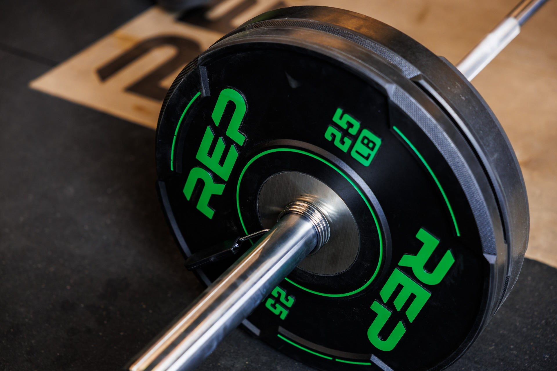 Close-up: A 25 lb REP Sport Bumper Plate 2.0 interlocks seamlessly with a 45 lb plate on the sleeve of a barbell