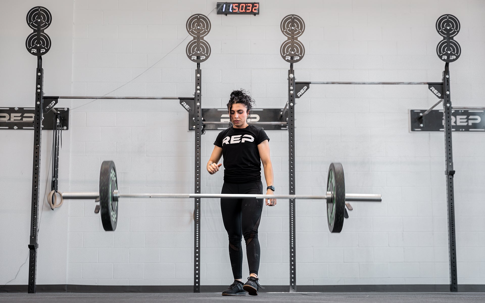 Athlete letting the bar drop after completing a clean and jerk using the REP 15kg Teton Training Bar.