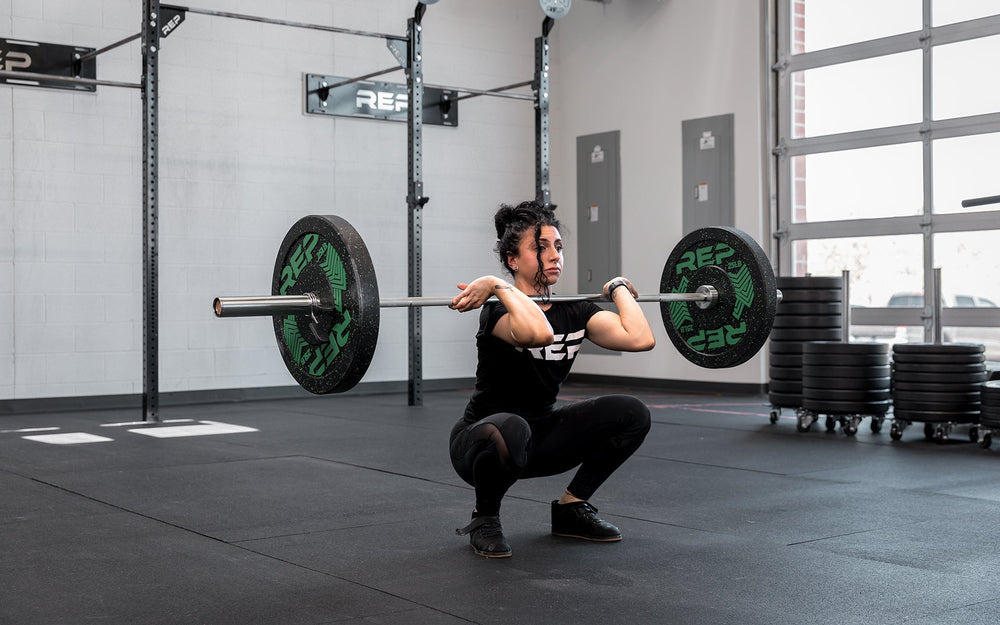 Athlete in the bottom of a clean using the REP 15kg Teton Training Bar.