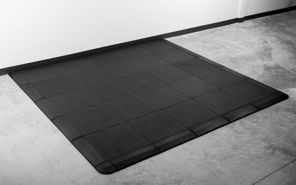 A set of the REP Fitness Interlocking Tiles with border and corner pieces up against a wall
