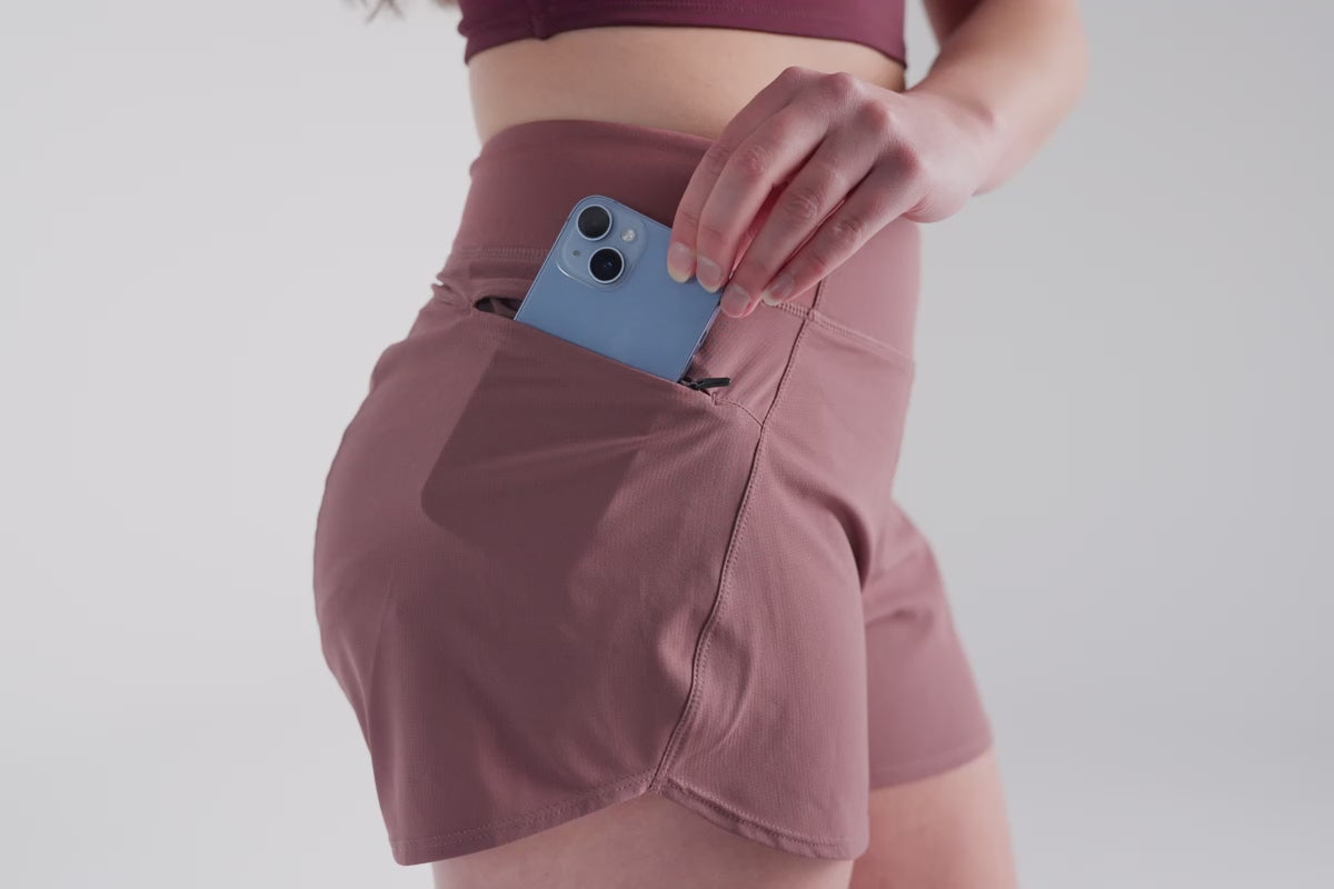 Video: Athlete putting their phone in the zipper pocket of the Mauve REP Artemis Short